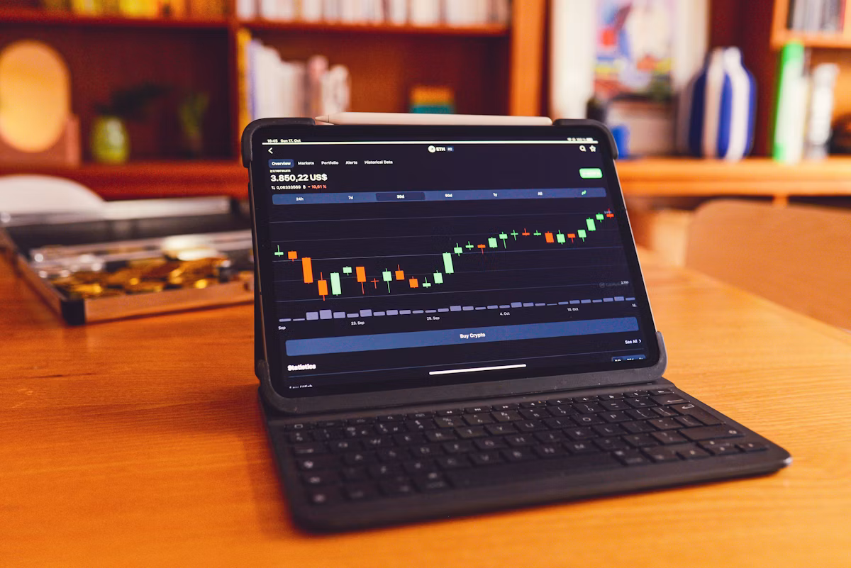 Laptop open on a wooden desk showing financial notes