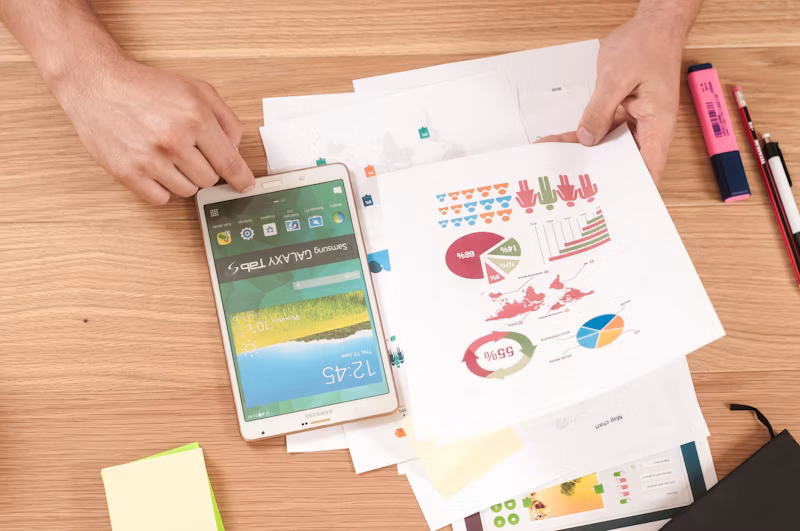 Person holding a tablet reviewing investment data